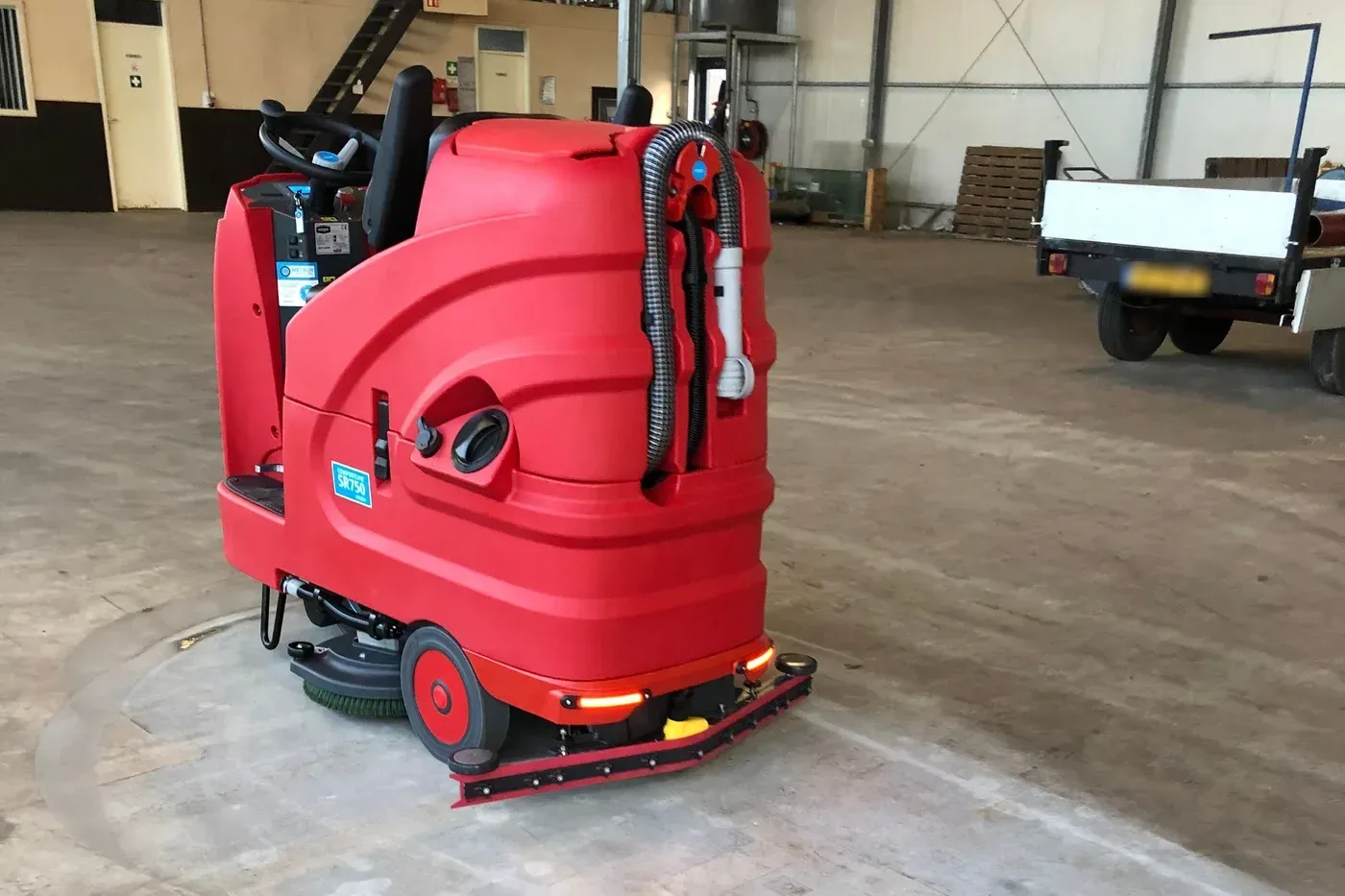 Rode Meijer SR750 opzitschrobmachine, schuin van achteren, in een lege bedrijfshal