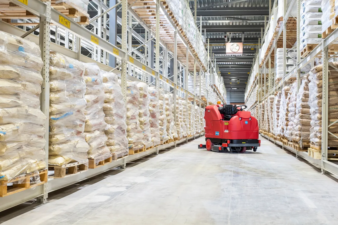 Meijer SR1200 opzitschrobmachine in een magazijngang tussen hoge palletstellingen