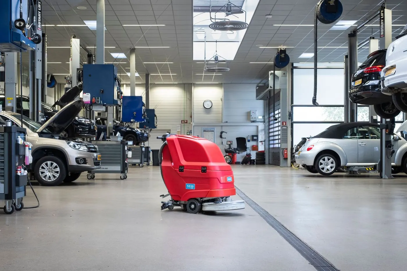 Meijer achterloopschrobmachine op de gladde vloer van een autowerkplaats