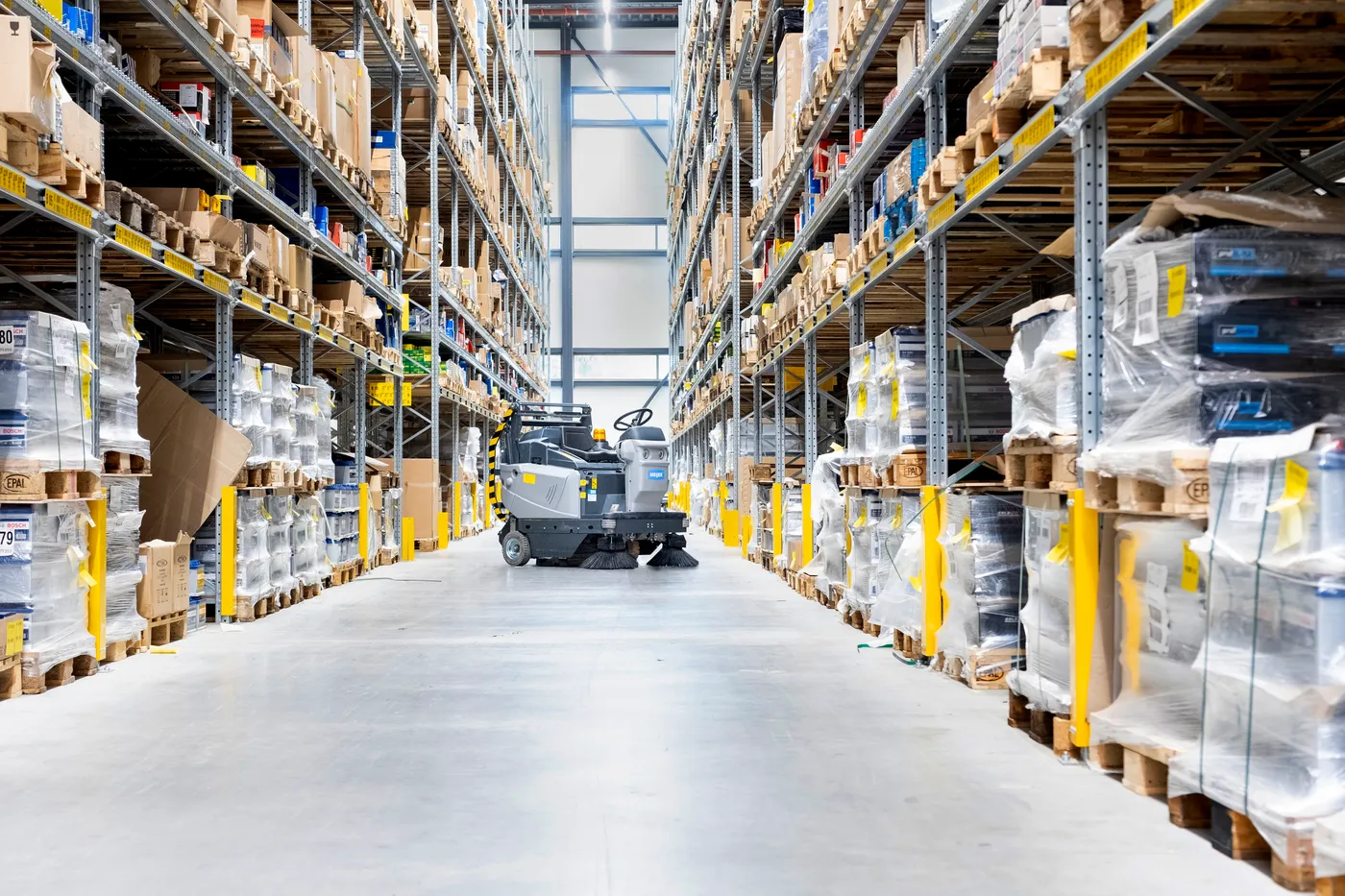 Meijer VR1300HD zitveegmachine in een magazijngang tussen hoge palletstellingen