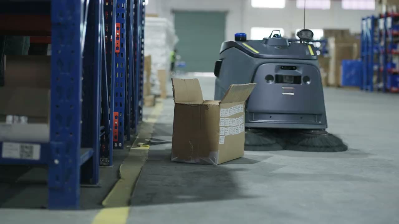 Beetle veegrobot in een magazijngang, naast een doos